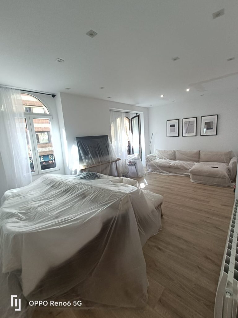 Muebles salón protegidos con plásticos y lonas durante reforma en Madrid – protección contra polvo y manchas en obra