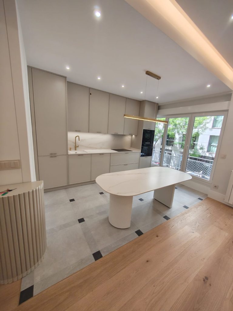 Salón comedor reformado en piso de Chamberí, Madrid, con cocina abierta integrada