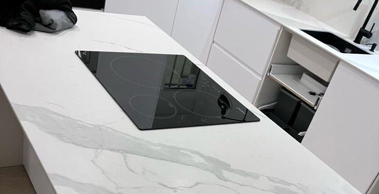 Encimera de porcelánico efecto Calacatta en cascada, reforma de cocina Fuencarral