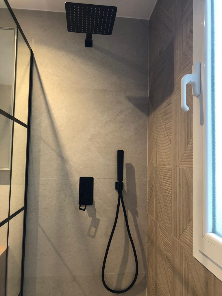 Baño reformado en Salamanca, Madrid, con ducha de obra, plato de resina y sanitario suspendido