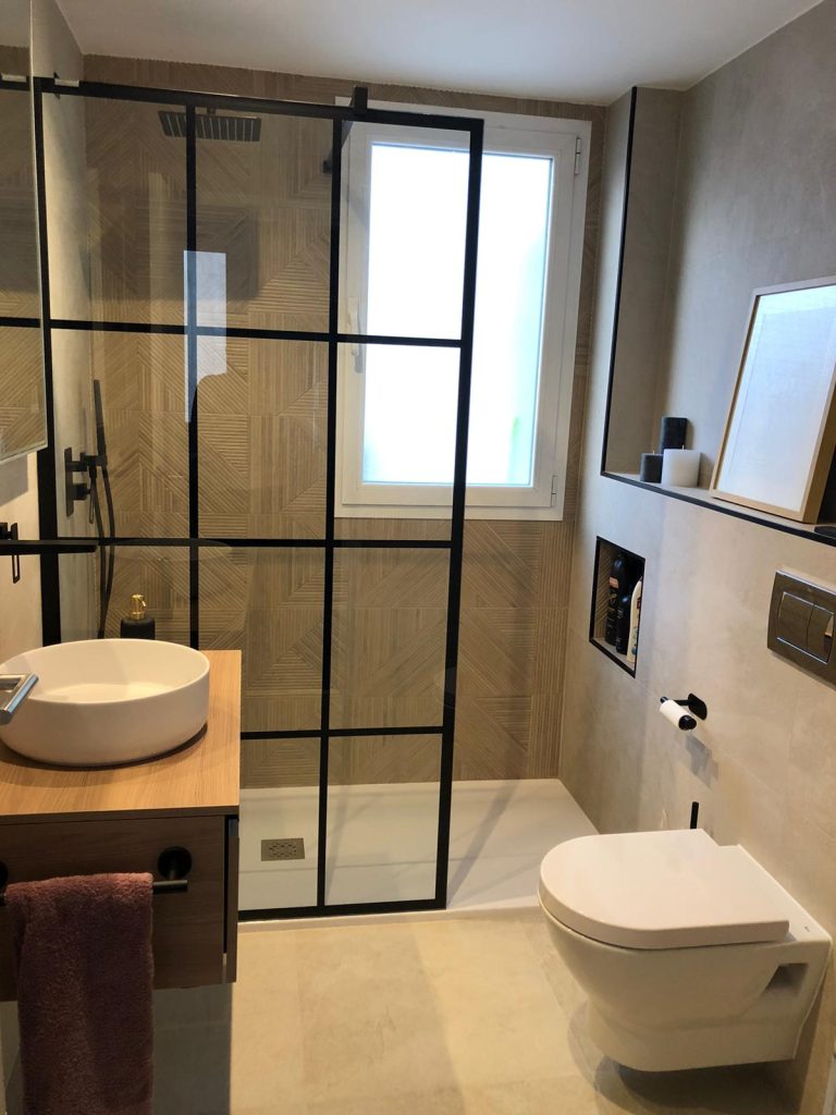 Mueble de baño suspendido con lavabo sobre encimera y espejo en reforma realizada en Salamanca, Madrid